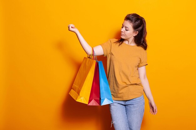 Mujer moderna llevando bolsas de compras después de comprar ropa