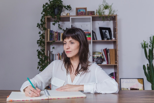 Mujer moderna en mesa escribiendo