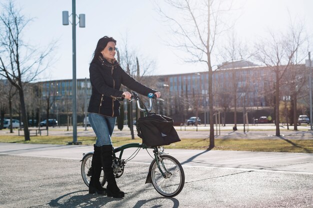 Mujer moderna montando en bici en ciudad