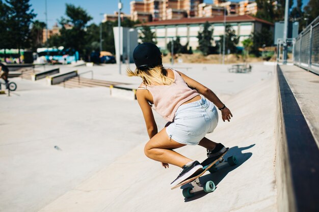 Mujer moderna, patineta y día soleado