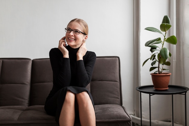 Mujer moderna sonriente hablando en el teléfono