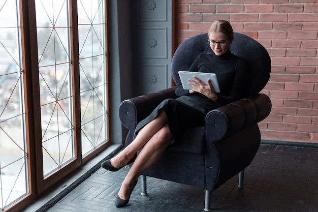 Mujer moderna con tableta en sofá