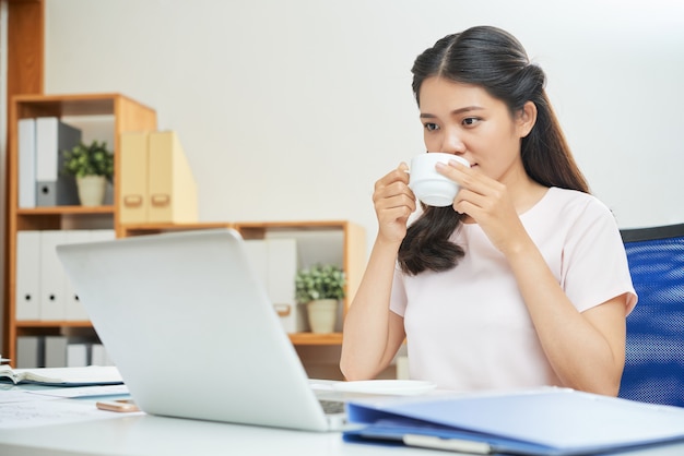 Mujer moderna tomando café en la oficina