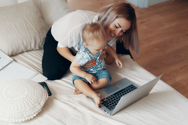 Mujer moderna trabajando con niños. Concepto multitarea, freelance y maternidad