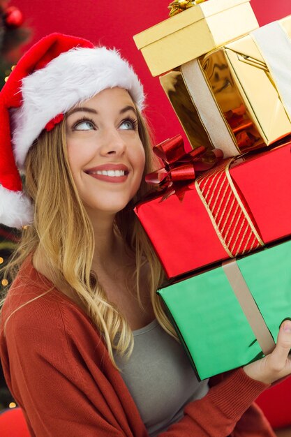 Mujer con una montaña de regalos de colores en sus manos