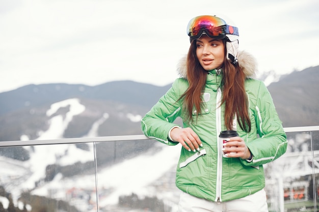 Mujer en las montañas el día de invierno. Dama con uniforme de esquí.