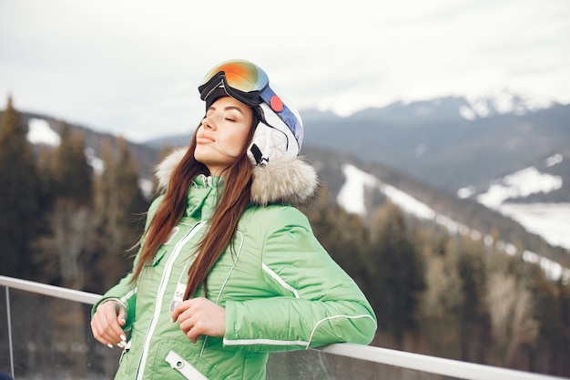 Mujer en las montañas el día de invierno. Dama con uniforme de esquí.