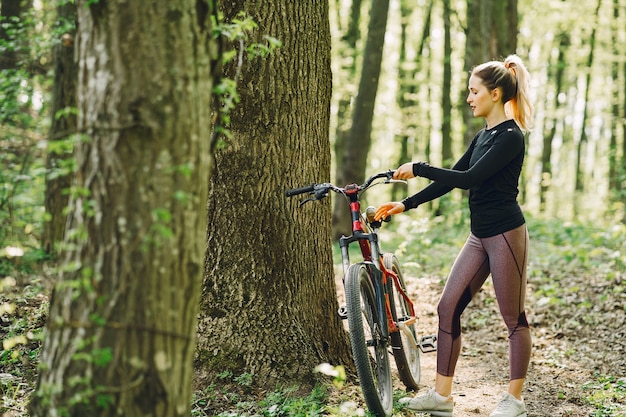 Mujer montando una bicicleta de montaña en el bosque