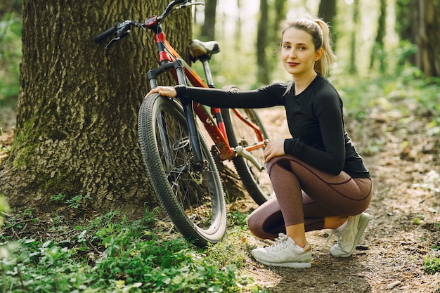 Mujer montando una bicicleta de montaña en el bosque