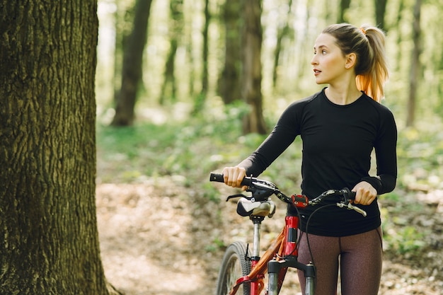 Mujer montando una bicicleta de montaña en el bosque