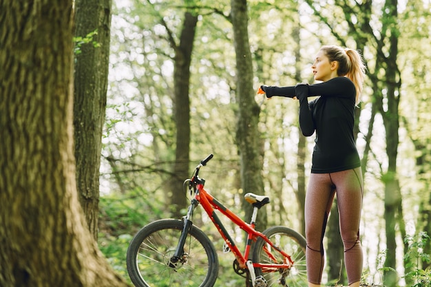 Mujer montando una bicicleta de montaña en el bosque