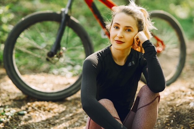 Mujer montando una bicicleta de montaña en el bosque