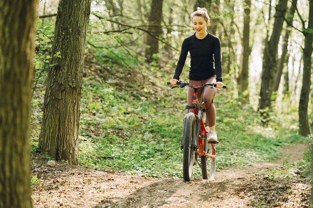 Mujer montando una bicicleta de montaña en el bosque