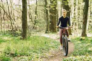 Foto gratuita mujer montando una bicicleta de montaña en el bosque
