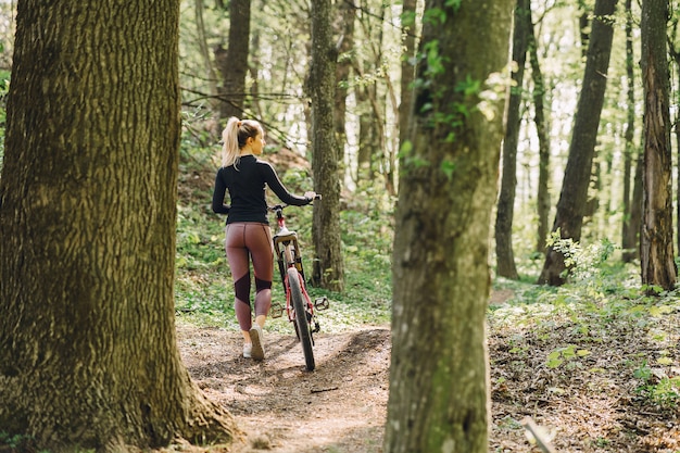 Mujer montando una bicicleta de montaña en el bosque