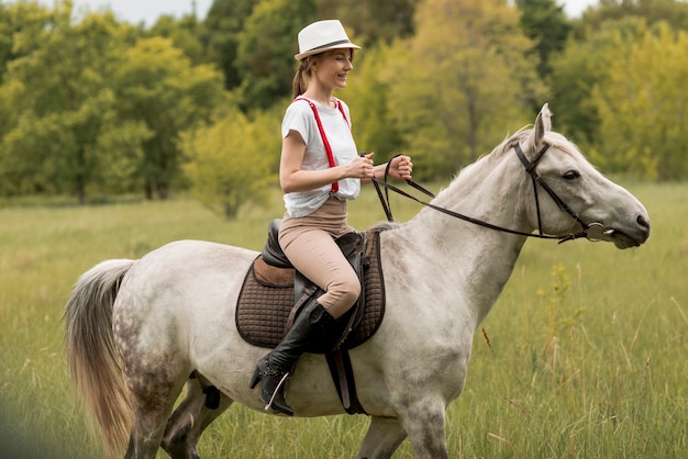 Mujer montando a caballo en el campo