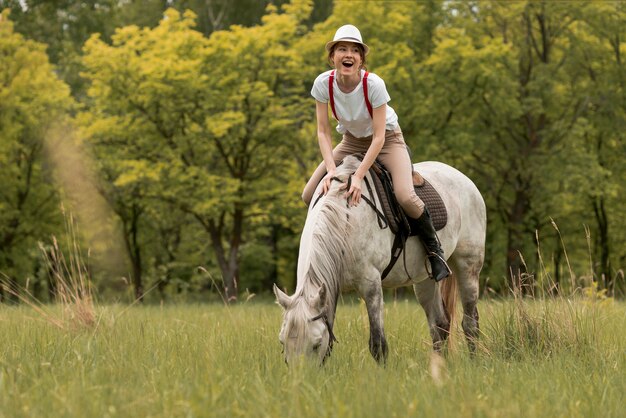 Mujer montando a caballo en el campo