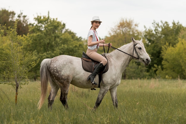 Mujer montando a caballo en el campo