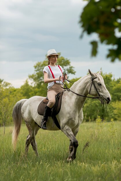 Mujer montando a caballo en el campo