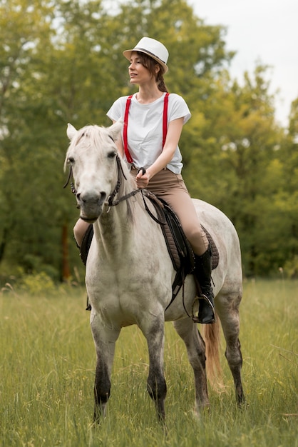 Foto gratuita mujer montando a caballo en el campo