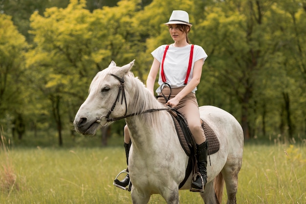 Mujer montando a caballo en el campo