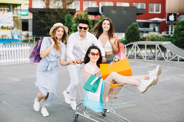 Mujer montando carrito de compras con sus amigos