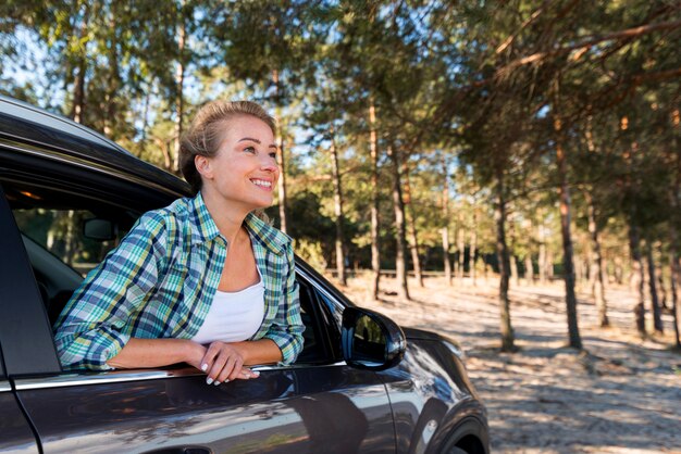 Mujer montando el coche en la naturaleza