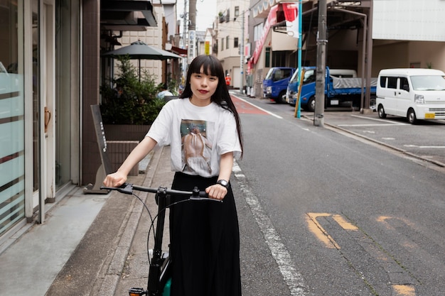 Mujer montando scooter eléctrico en la ciudad