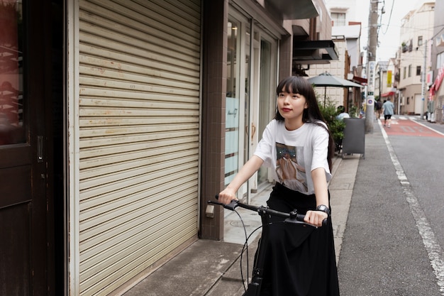 Mujer montando scooter eléctrico en la ciudad