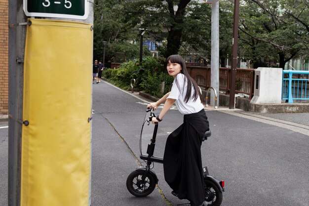 Mujer montando scooter eléctrico en la ciudad