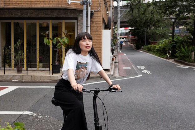 Mujer montando scooter eléctrico en la ciudad