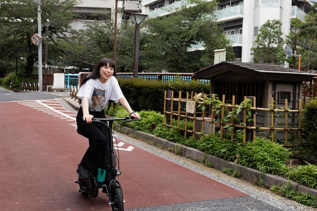 Mujer montando scooter eléctrico en la ciudad