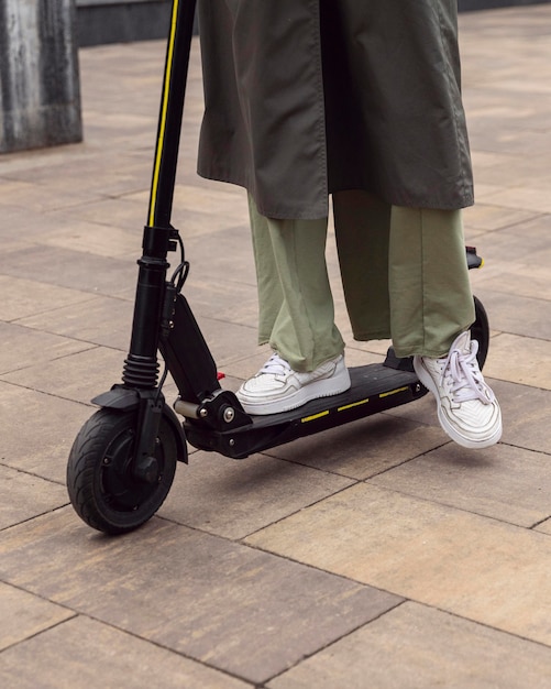 Mujer montando su scooter eléctrico al aire libre
