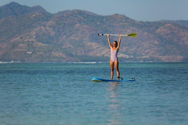 Mujer montando sup. . Bali. Indonesia