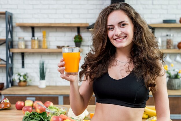 Foto gratuita mujer morena bebiendo zumo de naranja