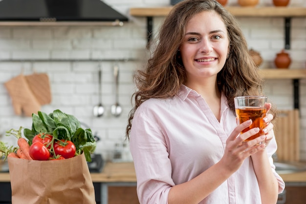 Foto gratuita mujer morena con bolsa de papel con alimentos sanos