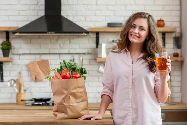 Mujer morena con bolsa de papel con alimentos sanos