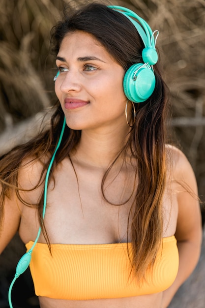 Mujer morena bonita con el pelo largo en auriculares