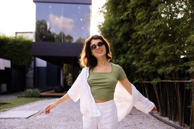 Mujer morena caucásica con gafas de sol mira la cámara