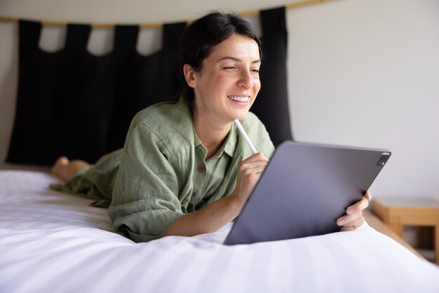 Mujer morena caucásica sonriendo a la computadora portátil