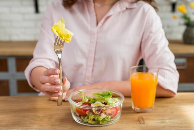 Mujer morena comiendo una ensalada