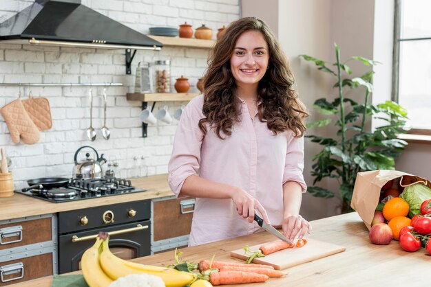 Mujer morena cortando zanahorias