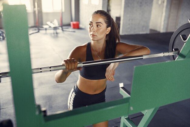 Mujer morena deportiva en un entrenamiento de ropa deportiva en un gimnasio