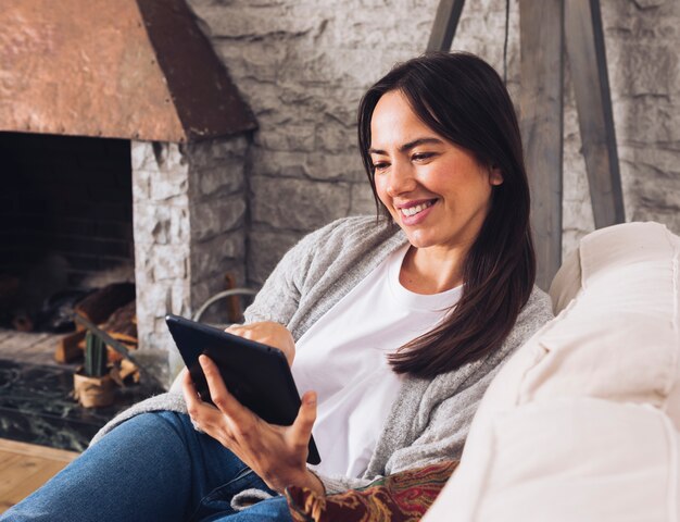 Mujer morena con dispositivo tecnológico.