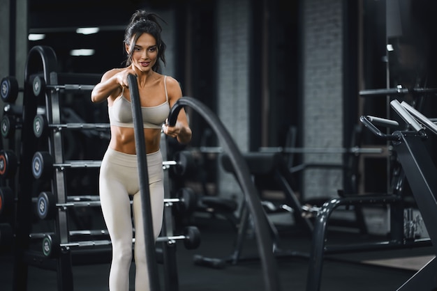 Mujer morena haciendo entrenamiento de cuerda de batalla.