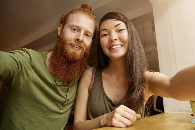 Mujer morena y hombre jengibre sentado en el café