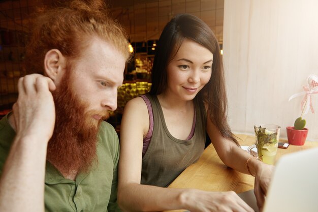 Mujer morena y hombre jengibre sentado en el café