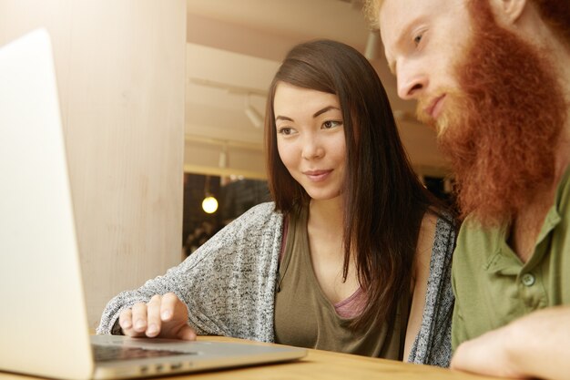 Mujer morena y hombre jengibre sentado en el café