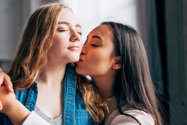 Foto gratuita mujer morena joven que besa al amor