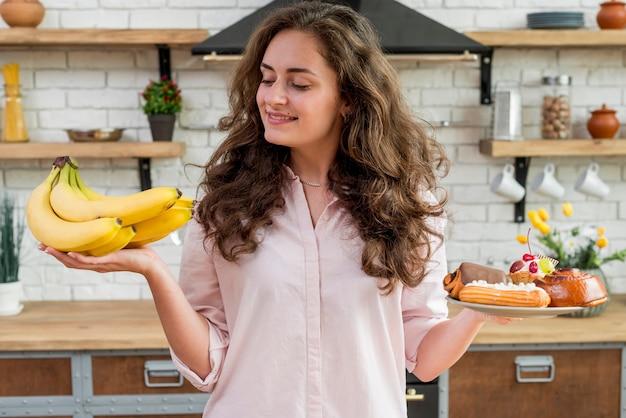 Foto gratuita mujer morena con plátanos y dulces